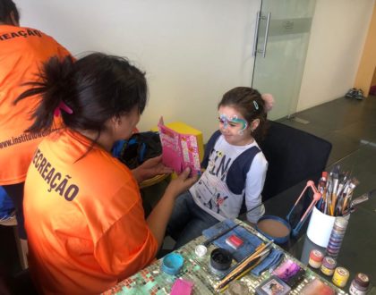 Recreadora e criança fazendo pintura facial