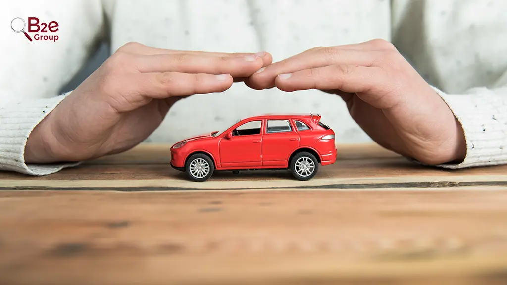 Mãos de uma pessoa segurando um carrinho vermelho sobre uma mesa de madeira, demonstrando o ato de Apropriação indébita.